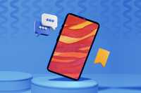 Enhance Your Psychedelic Trip. A blue background wall and floor with two round blue podiums, one which takes up the majority of the visible floor area. On this podium is a smartphone balancing on one of its corners. On the phone screen is a red, orange and yellow background.