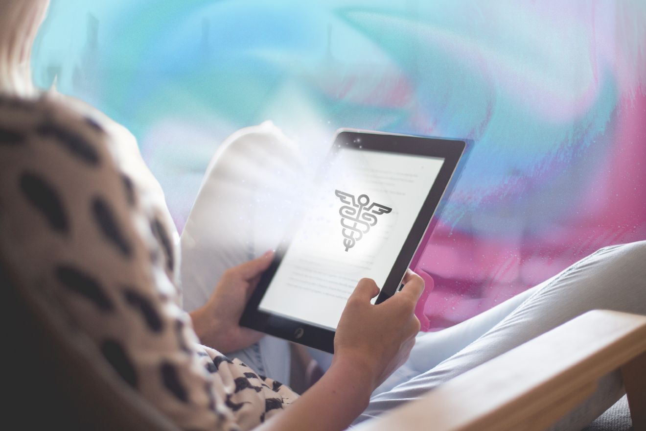 Articles-About-Ketamine. A woman sitting comfortably, engrossed in reading an ebook on her tablet about healthcare, soft focus, natural lighting, medical symbol hologram floating above the tablet.