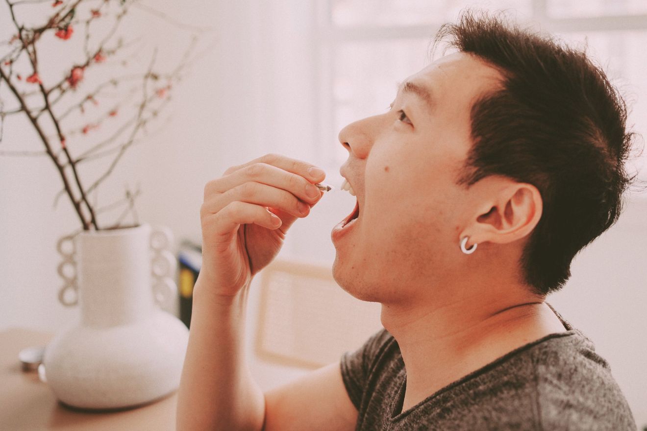 man eating psychedelic mushroom pill