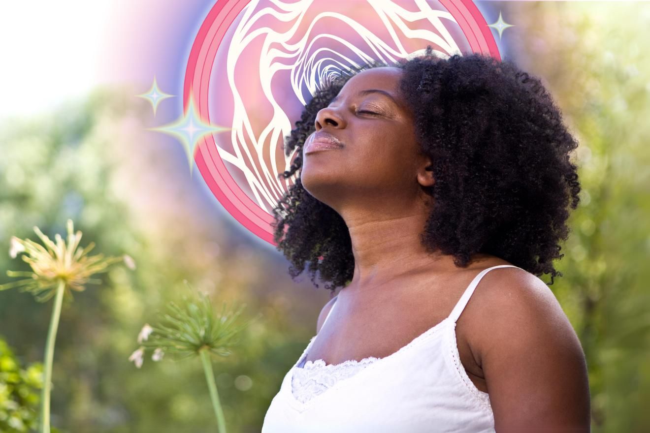 Psychedelic Journey Activities. Photo of a female-presenting person with dark skin and curly dark hair, wearing a white top, with their chin lifted and their eyes closed. They are in an out of focus nature scene, with a psychedelic vortex pattern behind their head.